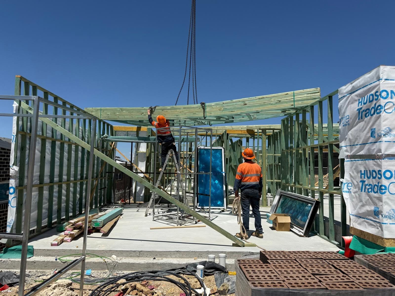Crew installing beams on a residential framing site