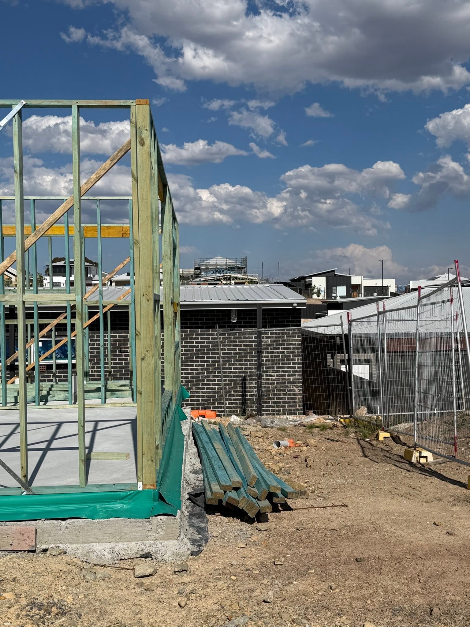 Framing materials staged at corner of build site
