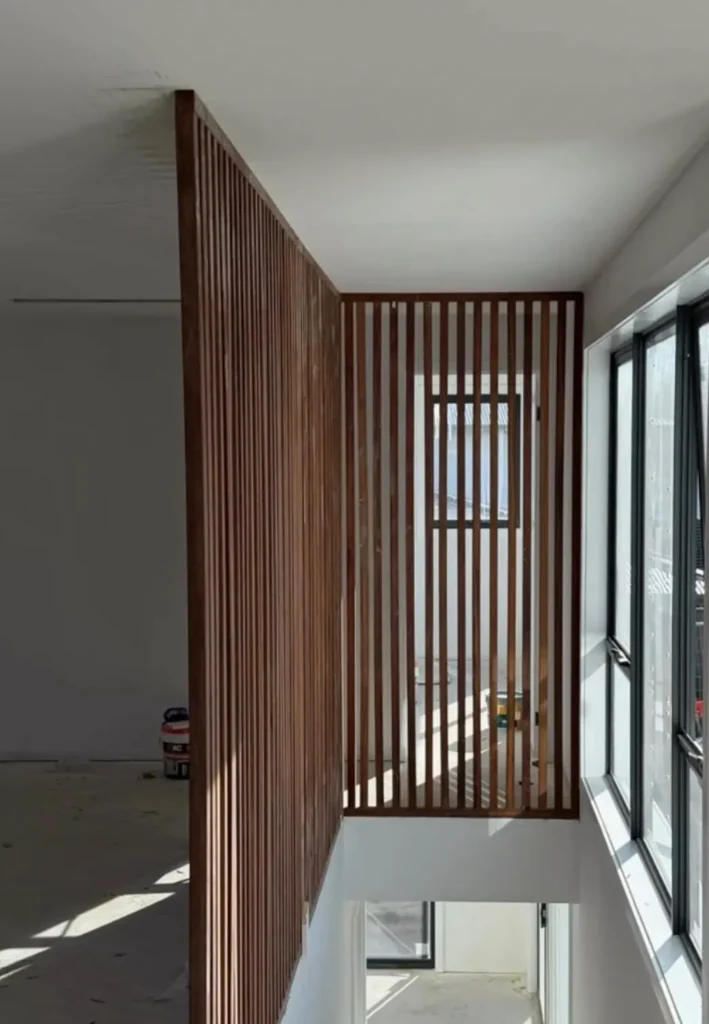 Vertical timber slat screen beside a staircase in a new home